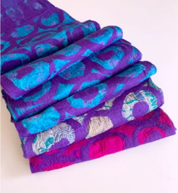Multi coloured scarf with primarily purple, blue, and pink tones and a circles design